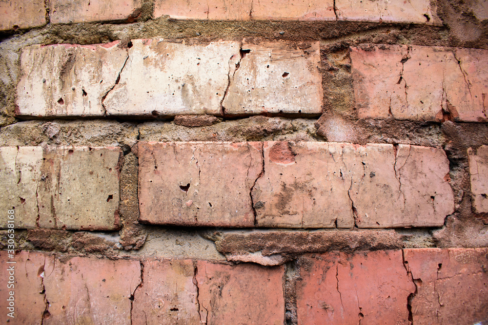 Old brick wall for backdrop. Thick joints made of concrete, cracks. Close-up. Shades of gray and red. Old brick wall for backdrop. Thick joints made of concrete, cracks. Close-up. Shades of gray and red.