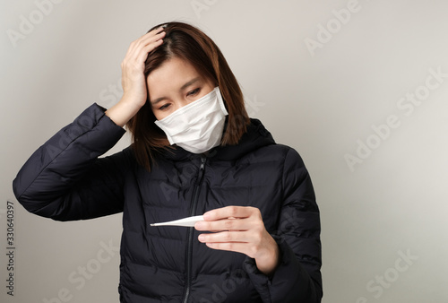 asian woman have fever and wear the medical mask to protect and fight infection from germ, bacteria, covid19, corona , sars , influenza virus on white background. Sick and illness concept photo