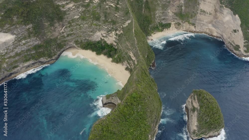 Bird eye view of Kelingking Beach with steep cliffs and waves crushing ashore, Nusa Penida, Bali, Indonesia Bird eye view of Kelingking Beach with steep cliffs and waves crushing ashore, Nusa Penida, Bali, Indonesia