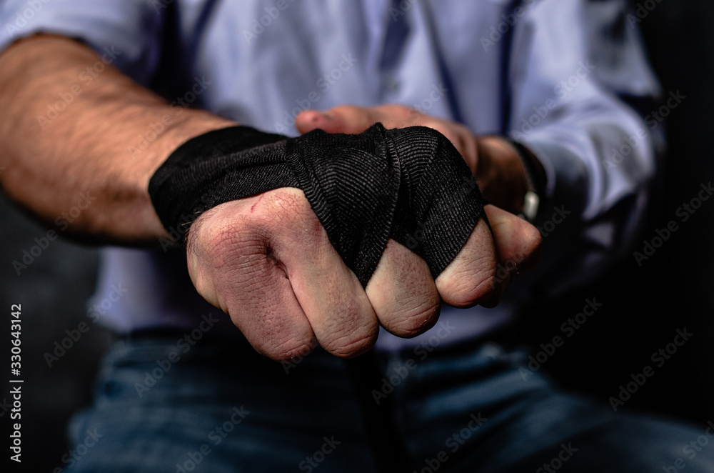 a man shows a fist in a Boxing bandage