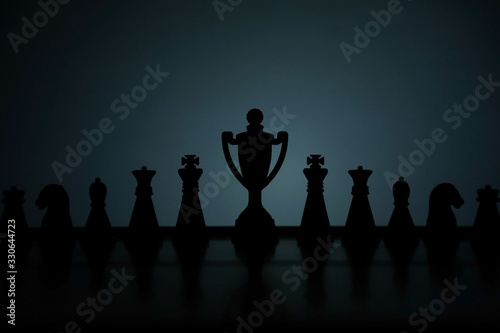 Business strategy conceptual photo – Silhouette of trophy stand in office table with chess pawn