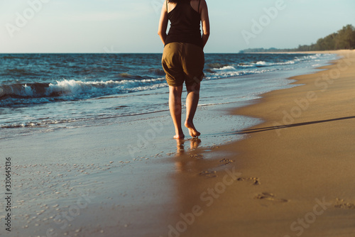 Vacation and holiday concept,Woman legs or foot walking on the beach,Back view