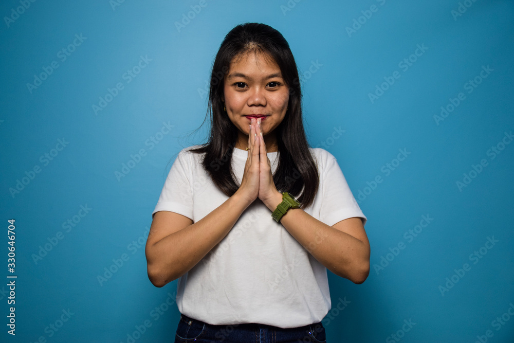 Portrait of Young beautiful asian women using white T-shirt with blue isolated background Portrait of Young beautiful asian women using white T-shirt with blue isolated background