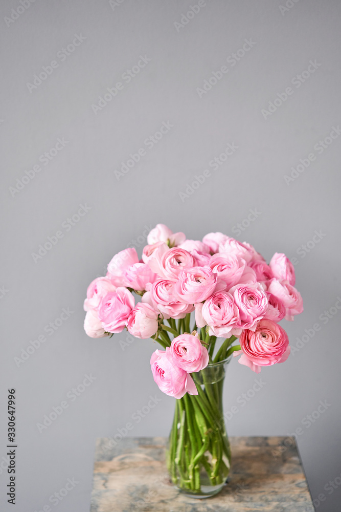 Spring background, flower Wallpaper. Persian buttercup. Bunch pink ranunculus flowers on light gray background. Vase on vintage wooden table. Wallpaper Spring background, flower Wallpaper. Persian buttercup. Bunch pink ranunculus flowers on light gray background. Vase on vintage wooden table. Wallpaper
