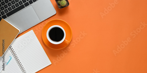 Top view image of Colorful working table. Flat lay Computer laptop, Cactus, Notebook, Diary, Pen and Coffee cup. Colorful workplace concept.