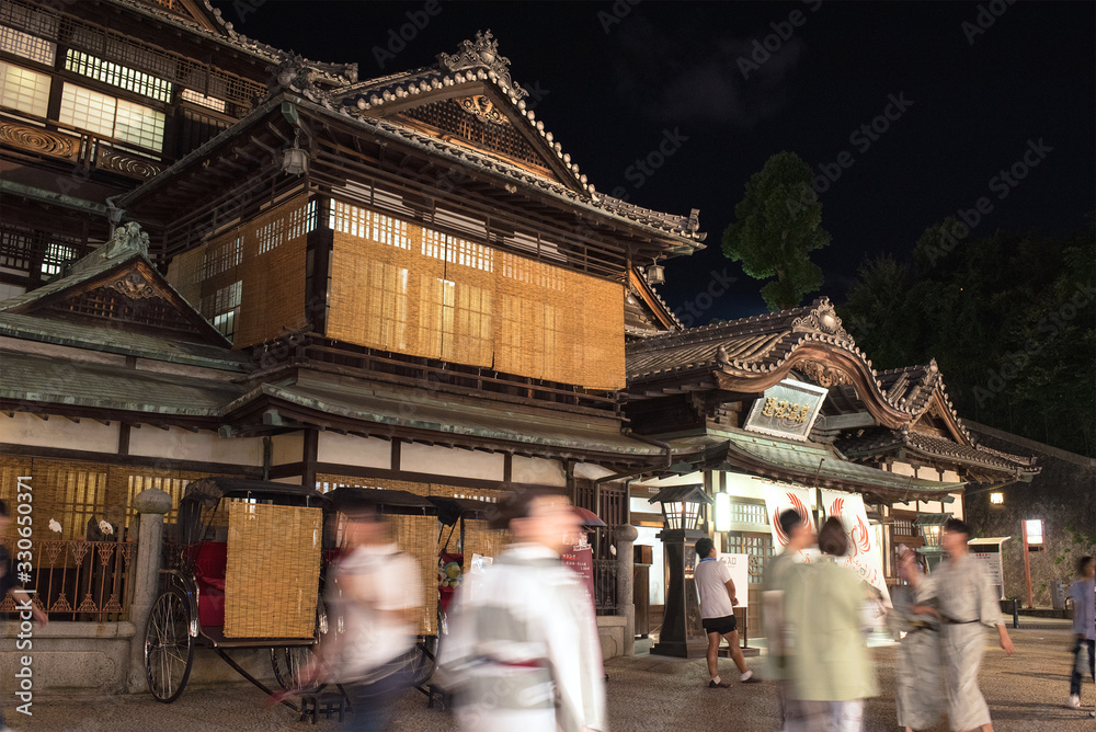 Φωτογραφία Dogo Onsen Honkan and tourists wearing Yukata at night, Matsuyama, Japan　夜の道後温泉本