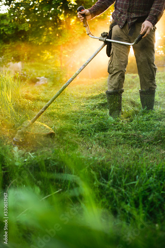 Man mowing the grass with trimmer