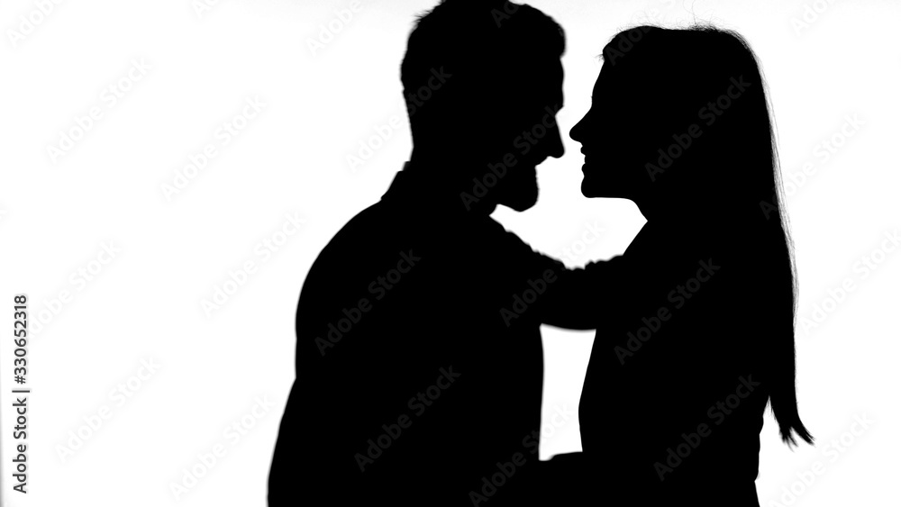 The Silhouette of Young Couple Hugging Against White Background