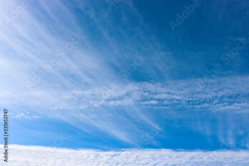 Cirrus and Cirrocumulus clouds against the blue sky. Natural background. Atmospheric phenomena.