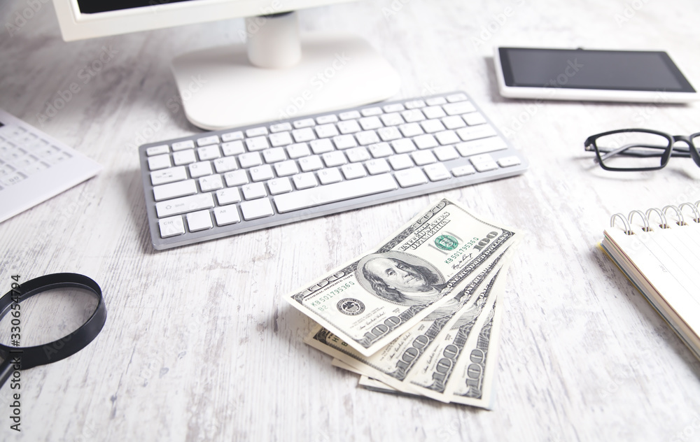 Hundred dollar banknotes with a computer keyboard, tablet and calculator. Hundred dollar banknotes with a computer keyboard, tablet and calculator.