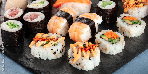 Large sushi set, close-up panorama. An assortment of various maki, nigiri and rolls