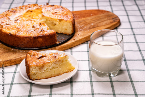 cut off part homemade cake and glass milk wooden