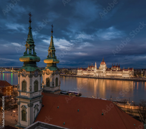 Budapest, Hungary - Aerial view of the Saint Anne Parish Church at Batthyany Square at dusk with illuminated Hungarian Parliament building at background