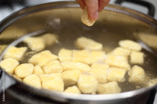 Gnocchi being prepared. Adding into boiled water. Dough dumplings with cheese.