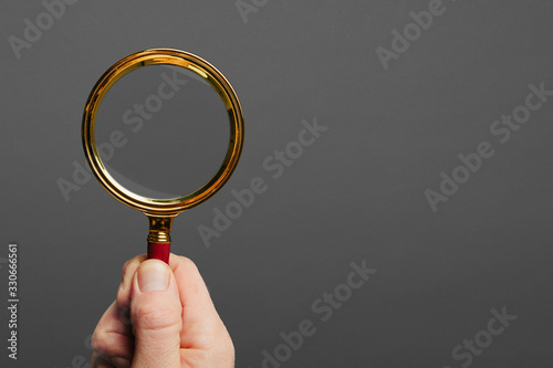 man holds a magnifier on a black background