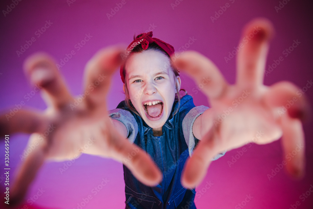 Young stylish girl in the Studio on a colored neon background. Music dj poster design. Portrait of a young girl dancer. Young stylish girl in the Studio on a colored neon background. Music dj poster design. Portrait of a young girl dancer.