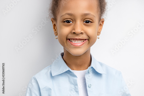 close-up portrait of african on half, little girl with curly hair. child with smiling face. isolated over white background