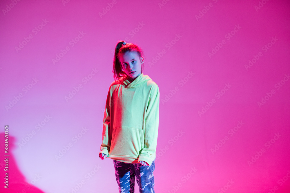 Young stylish girl dancing in the Studio on a colored neon background. Music dj poster design. Young stylish girl dancing in the Studio on a colored neon background. Music dj poster design.