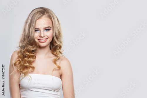 Attractive woman fashion model with blonde hair smiling on white background