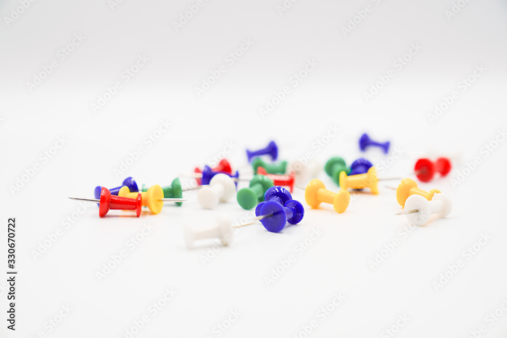 Some colorful pushpins on white paper Some colorful pushpins on white paper