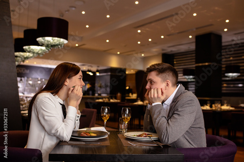 beautiful caucasian couple on a date in rich restaurant. they have dinner together  eat delicious tasty food and drink champagne. happy married couple indoors