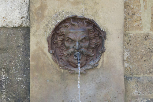 gargoyle spitting water at a well in Pitigliano photo