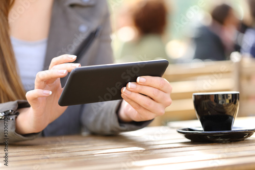 Woman hands watching videos on phone on a cafe terrace