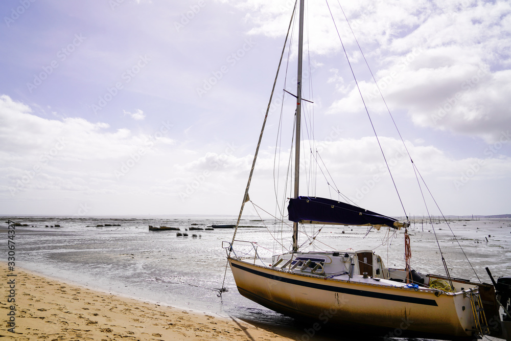 Sailboat at low tide at Arès in Arcachon Bay in Gironde southwest France