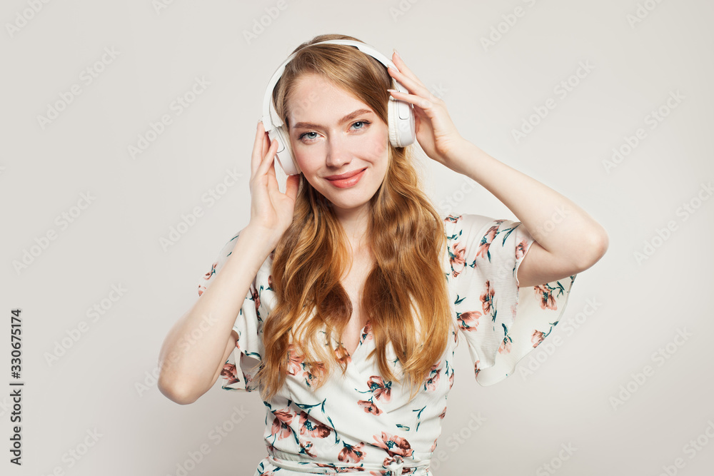 Happy woman with headphones. Redhead model girl having fun on white background Happy woman with headphones. Redhead model girl having fun on white background