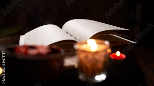 Fortune teller room with open book of predictions on table with candles