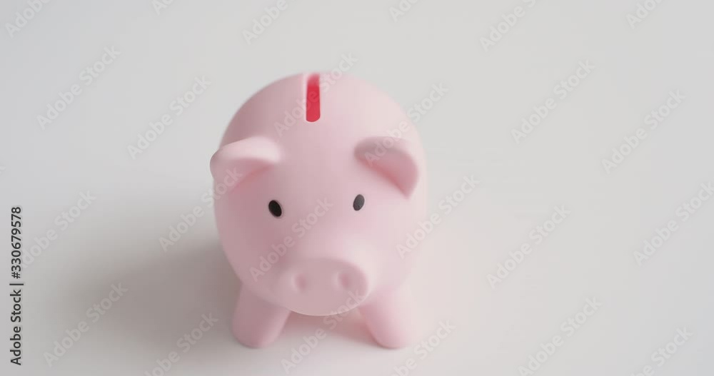 Female hand putting coin into pink piggy bank box. Woman making savings, taking loan, investing money. Bank deposit, financial economy for wealthy future, accounting and charity concept. Close up view Female hand putting coin into pink piggy bank box. Woman making savings, taking loan, investing money. Bank deposit, financial economy for wealthy future, accounting and charity concept. Close up view