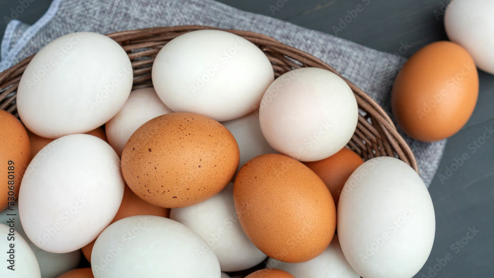 Chicken egg and duck egg on a black wooden table.