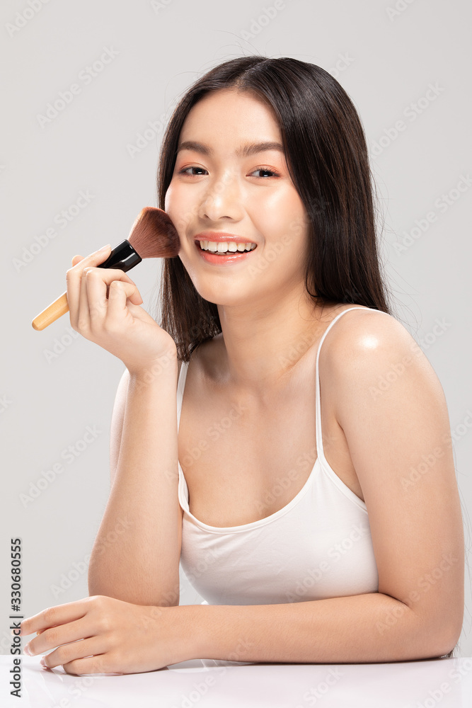 Beautiful Asian young woman smile and holding make up brush with healthy Clean and Fresh skin feeling so happiness and cheerful,Isolated on white background,Beauty Cosmetics Concept Beautiful Asian young woman smile and holding make up brush with healthy Clean and Fresh skin feeling so happiness and cheerful,Isolated on white background,Beauty Cosmetics Concept