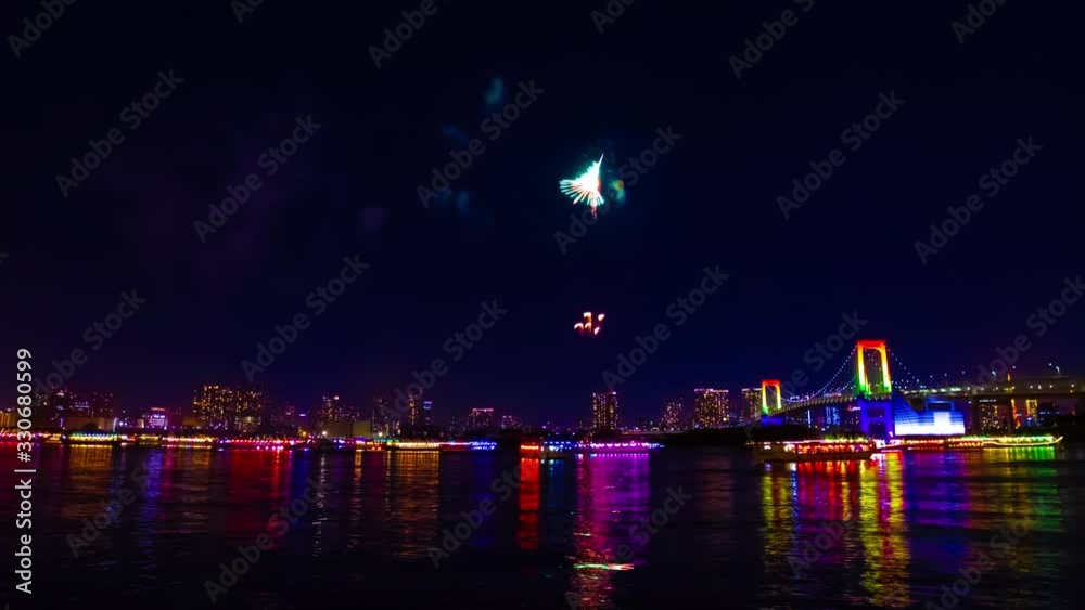 A night timelapse of fireworks near Rainbow bridge at the urban city in Tokyo