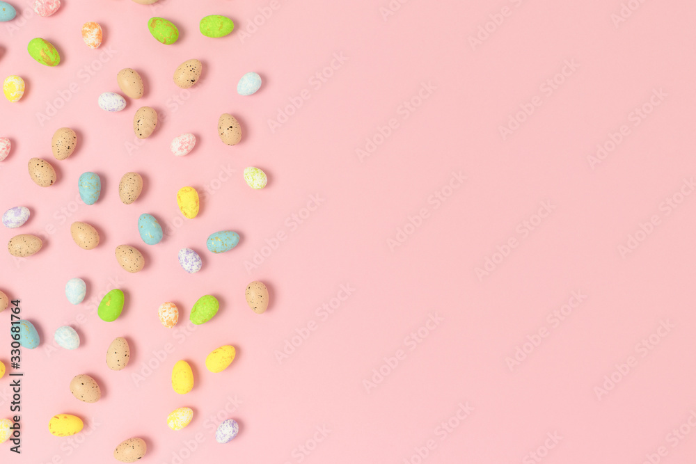 Frame made of colorful easter eggs on a pink pastel background. Holiday creative concept with place for text.