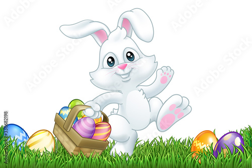 Easter bunny rabbit cartoon character holding a basket full of painted Easter eggs in a field of grass.