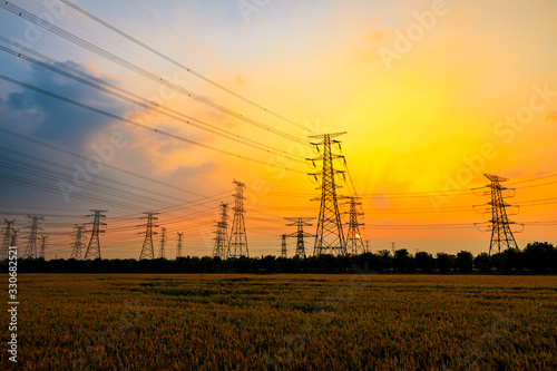 Industrial high voltage electricity tower and beautiful nature landscape at summer sunset
