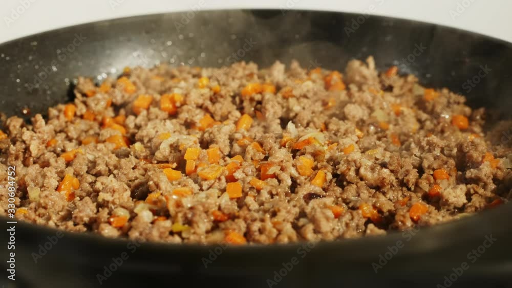 Minced meat fried in a frying pan. Close-up of cooking Bolognese meat sauce in frying pan Minced meat fried in a frying pan. Close-up of cooking Bolognese meat sauce in frying pan