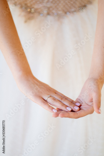 hands of bride wedding ring on background of dress