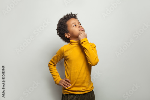 Curious black child looking up on white background