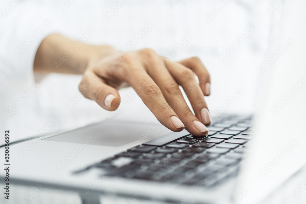 Woman typing on laptop keyboard in sunny office, business and technology concept. Close up Woman typing on laptop keyboard in sunny office, business and technology concept. Close up