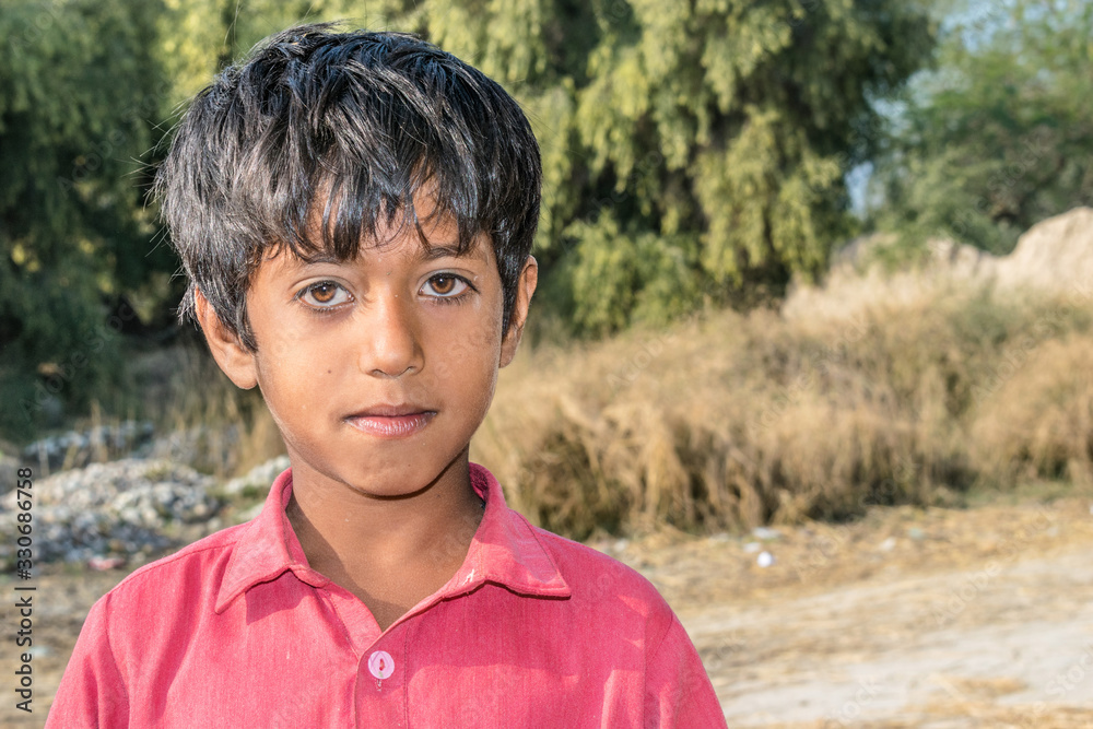 closeup of a poor staring hungry orphan boy in a refugee camp with sad expression on his face and his face and clothes are dirty and his eyes are full of pain closeup of a poor staring hungry orphan boy in a refugee camp with sad expression on his face and his face and clothes are dirty and his eyes are full of pain