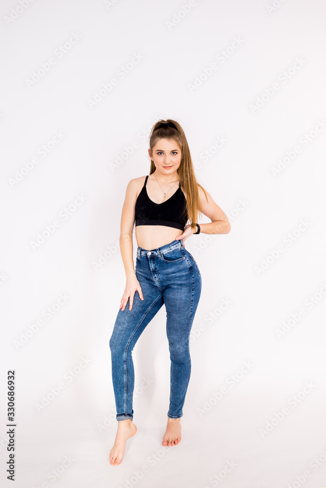 fitness women on a white background in jeans and a sports top fitness women on a white background in jeans and a sports top