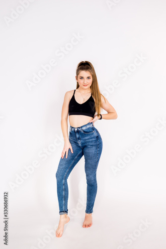 fitness women on a white background in jeans and a sports top