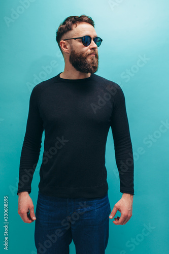 Handsome american hipster guy with beard wearing black long sleeve t-shirt or sweater with space for your brand name or label. Mockup for print