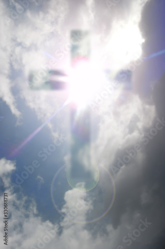 cloudy and heavenly cross with bright rays against the sky