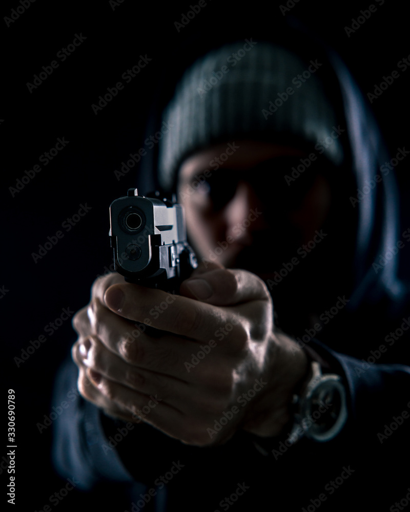 Man in Dark Hoodie Pointing Gun Close Up Man in Dark Hoodie Pointing Gun Close Up