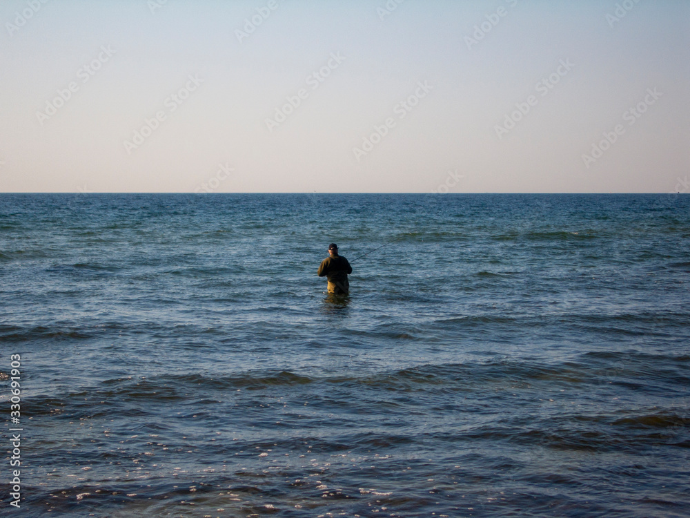old man fishing in the sea at sunset old man fishing in the sea at sunset