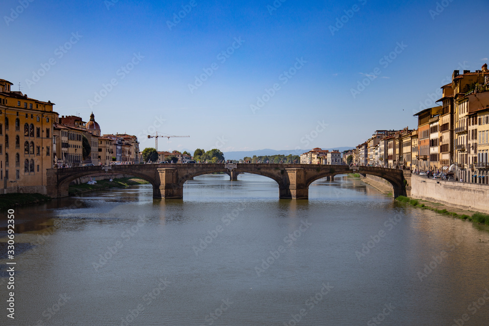 FLORENCE, ITALY - September, 2019: Italian traditional houses and architecture over Arno river with blue sky in Florence, Italy.