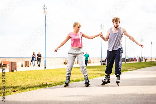 Active young people friends rollerskating outdoor.